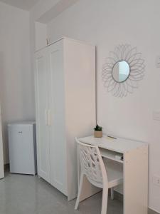 a white desk with a mirror and a white cabinet at Rovelli House in Foggia