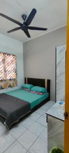 um quarto com uma cama e uma ventoinha de tecto em Homestay Atikah Bahau em Bahau