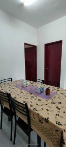 une table avec un tissu de table et deux chaises dans l'établissement Homestay Atikah Bahau, à Bahau