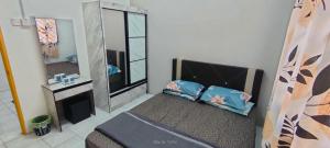 a bedroom with a bed and a mirror at Homestay Atikah Bahau in Bahau