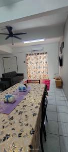 ein Wohnzimmer mit einem Tisch und einem Deckenventilator in der Unterkunft Homestay Atikah Bahau in Bahau