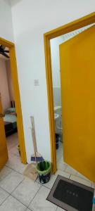 a bathroom with a yellow door and a tile floor at Homestay Atikah Bahau in Bahau