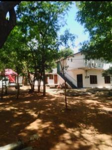 a white building with trees in front of it at New Samanalee Resort in Kataragama