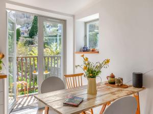 a dining room with a table and a balcony at Earthspring Flat in Totnes