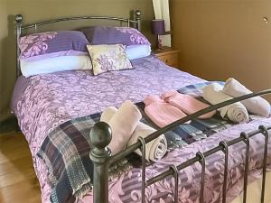 łóżko z różową i fioletową pościelą i poduszkami w obiekcie Foxglove - Uk45988 w mieście Paul
