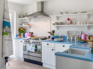 a kitchen with white cabinets and blue counter tops at The Owl Nest-uk46927 in Newby Bridge