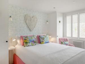 a bedroom with a white bed with a heart on the wall at The Owl Nest-uk46927 in Newby Bridge