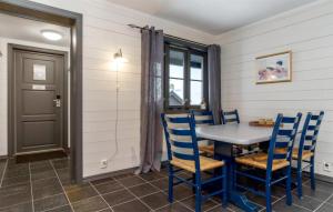 a dining room with a table and blue chairs at Nice Apartment In Hemsedal With House A Mountain View in Hemsedal