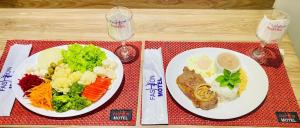 a table with two plates of food and two wine glasses at Motel Fashion ABC 2 in Santo André +3 photos