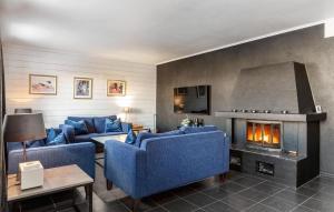 a living room with blue couches and a fireplace at Nice Apartment In Hemsedal With House A Mountain View in Hemsedal