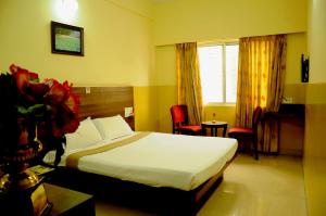 a hotel room with a bed and a window at Suvarna Residency in Mysore +50 photos