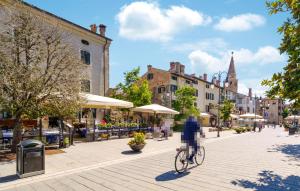 une personne voyageant à vélo dans une rue de la ville dans l'établissement 2 Bedroom Cozy Apartment In Gorizia, à Gorizia