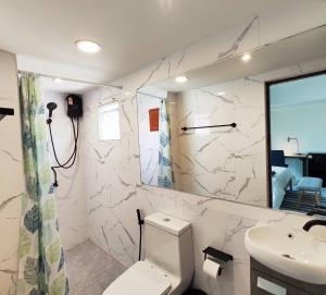 La salle de bains est pourvue de toilettes et d'un lavabo. dans l'établissement Suneta Hostel Chiangmai, à Chiang Mai