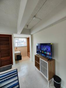 a living room with a flat screen tv on a wall at Suneta Hostel Chiangmai in Chiang Mai