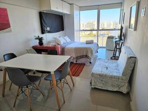 una camera da letto con un letto, un tavolo e delle sedie di Fantastic spot: Studio w/parking 2 blocks to World Trade Center, 3 to beach a Montevideo