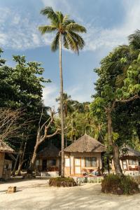a palm tree in front of a house at Mayalay Resort-Green Hotel in Ko Ngai