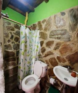 a bathroom with a toilet and a sink at Hostal El Santuario in Minca