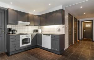 eine Küche mit grauen Schränken und weißen Geräten in der Unterkunft 3 Bedroom Nice Apartment In Hemsedal in Hemsedal