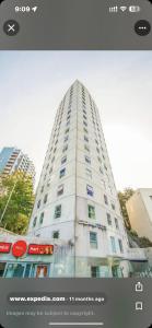 a tall white building with a picture of it at City room in apartment near University in Auckland