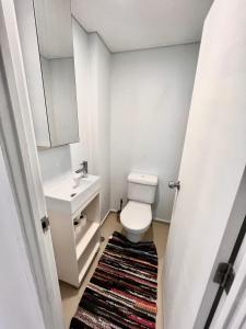 a small bathroom with a toilet and a sink at City room in apartment near University in Auckland
