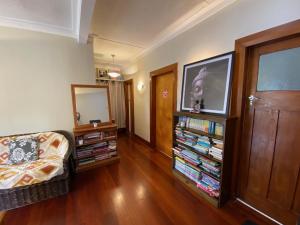 a living room with a couch and a tv and books at Wellington double bedroom in Wellington