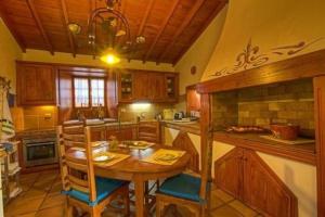 una cucina con tavolo in legno e soffitto in legno di Ferienhaus in La Caridad mit Terrasse, Grill und Whirlpool a Adelantado