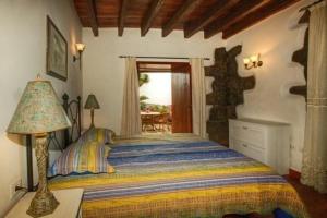 una camera con letto e tavolo con lampada di Ferienhaus in La Caridad mit Terrasse, Grill und Whirlpool a Adelantado