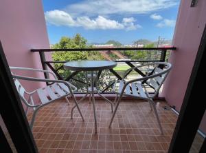 een tafel en stoelen op een balkon met uitzicht bij ธารา นาคา อพาสเม้นต์ in Ban Rangeng