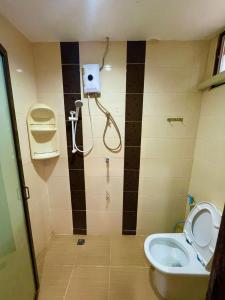 een badkamer met een toilet en een douche bij ธารา นาคา อพาสเม้นต์ in Ban Rangeng