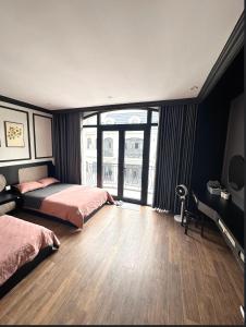 um quarto com 2 camas e uma grande janela em H+homestay em Hòa Bình