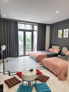 um quarto com 2 camas e uma grande janela em H+homestay em Hòa Bình