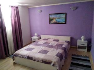 - une chambre avec un lit et un mur violet dans l'établissement Ferienwohnung für 4 Personen ca 65 qm in Zelenka, Dalmatien Mitteldalmatien, à Makarska