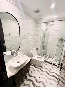 uma casa de banho com um WC, um lavatório e um chuveiro em H+homestay em Hòa Bình