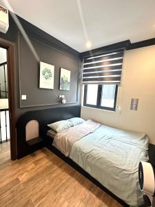 um quarto com uma cama e uma janela em H+homestay em Hòa Bình