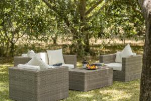 three wicker chairs and a table in the grass at Jasper Cub in Wilpattu