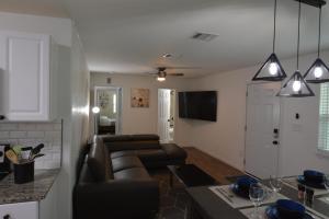 Il comprend un salon avec un canapé en cuir et une cuisine. dans l'établissement Duplex house 2214 Pine Street, à Grand Prairie