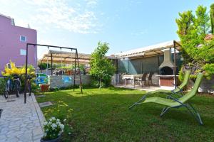 um quintal com uma cadeira verde e uma casa em Ferienwohnung für 4 Personen ca 50 qm in Fažana, Istrien Istrische Riviera em Fažana