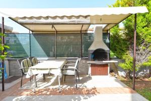 un patio con mesa, sillas y parrilla en Ferienwohnung für 4 Personen ca 50 qm in Fažana, Istrien Istrische Riviera en Fažana