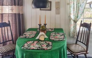 a table with a green table cloth and candles on it at 3 Bedroom Beautiful Home In Rmskog in Rømskog