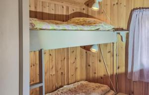 two bunk beds in a room with wooden walls at 3 Bedroom Beautiful Home In Rmskog in Rømskog