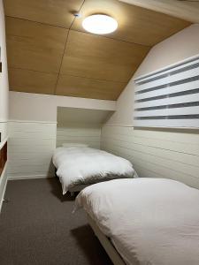 una camera con due letti e una finestra di Origami Chalet - Riverside a Hakuba