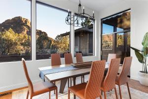 comedor con mesa, sillas y ventanas grandes en Mammoth Rock Lodge-New Family Home REMODELED 2 Hot Tubs & Game Room, en Sedona
