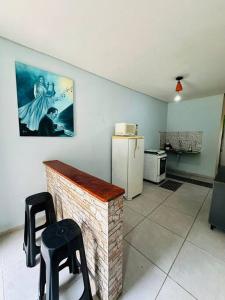 eine Küche mit einem Kühlschrank und 2 Hockern in einem Zimmer in der Unterkunft APTO Mobiliado Aconchegante Serra Cantareira Cod 1 in Caieiras