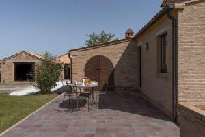 un patio con mesa y un edificio de ladrillo en Ferienhaus mit Privatpool für 12 Personen ca 350 qm in Loro Piceno, Marken Provinz Macerata, en Loro Piceno
