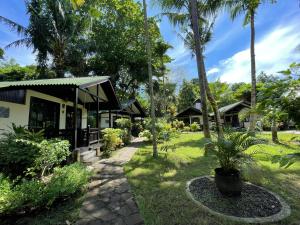 um resort com palmeiras e um edifício em The Village Bunaken em Bunaken