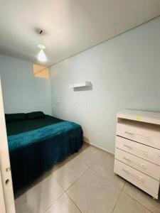 ein Schlafzimmer mit einem grünen Bett und einer Kommode in der Unterkunft APTO Mobiliado Aconchegante Serra Cantareira Cod 1 in Caieiras