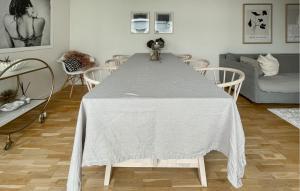 einen Tisch mit einem weißen Tischtuch darauf im Wohnzimmer in der Unterkunft Nice Home In Ambjrnarp With Lake View in Ambjörnarp