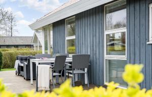una terrazza con sedie, tavolo e finestre di Stunning Home In Juelsminde With Wifi a Sønderby Altre 10 foto