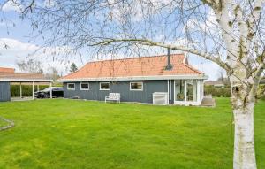 una casa gris con techo rojo en un patio en Stunning Home In Juelsminde With Wifi, en Sønderby