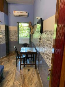 comedor con mesa y 2 sillas en AURO GUEST HOUSE en Auroville